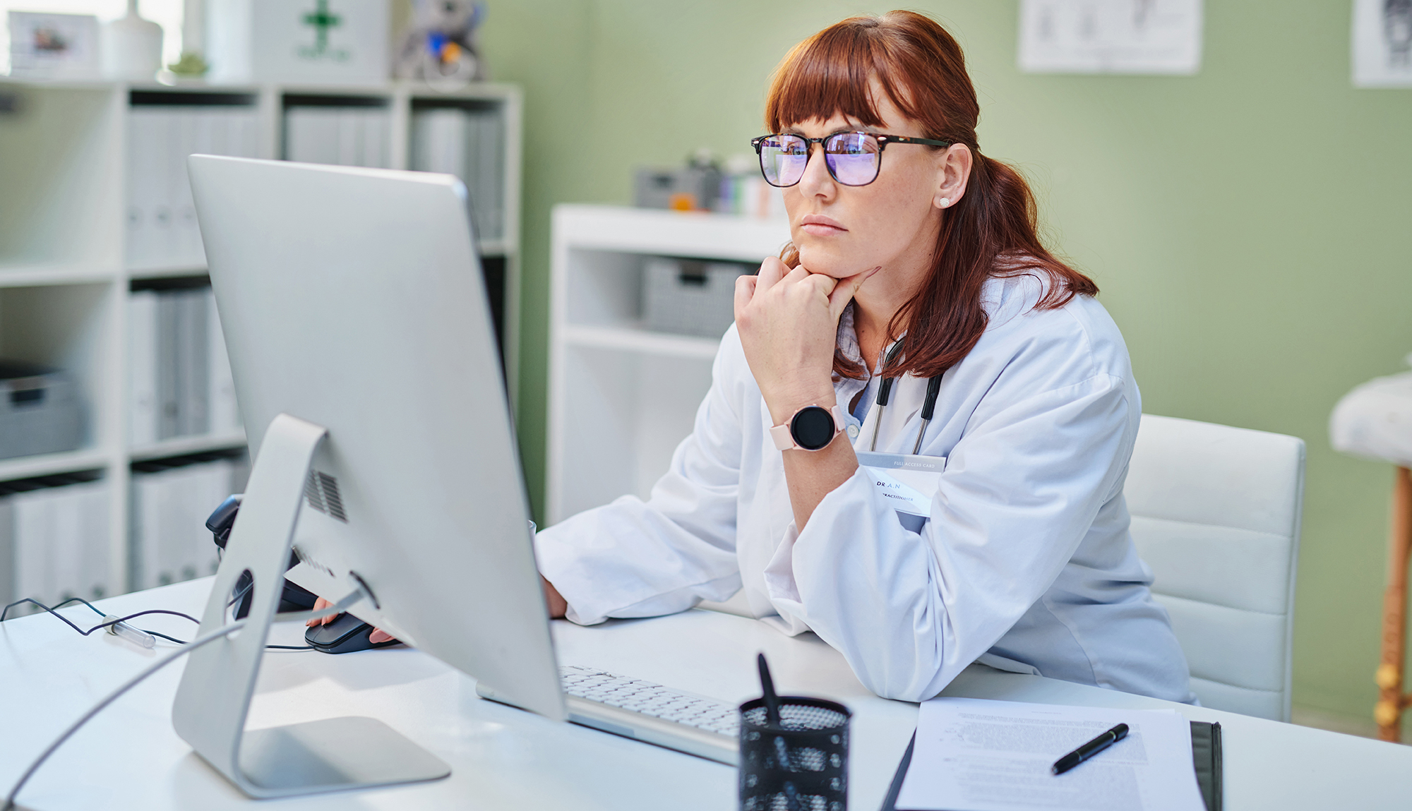 A female healthcare provider sitting at her computer and taking a continuing education course.