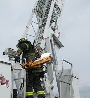 A fire chief demonstrates the challenges in accessing an aerial ladder and truck steps.