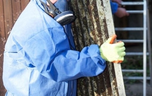 Worker wearing respirator removing a dirty filter