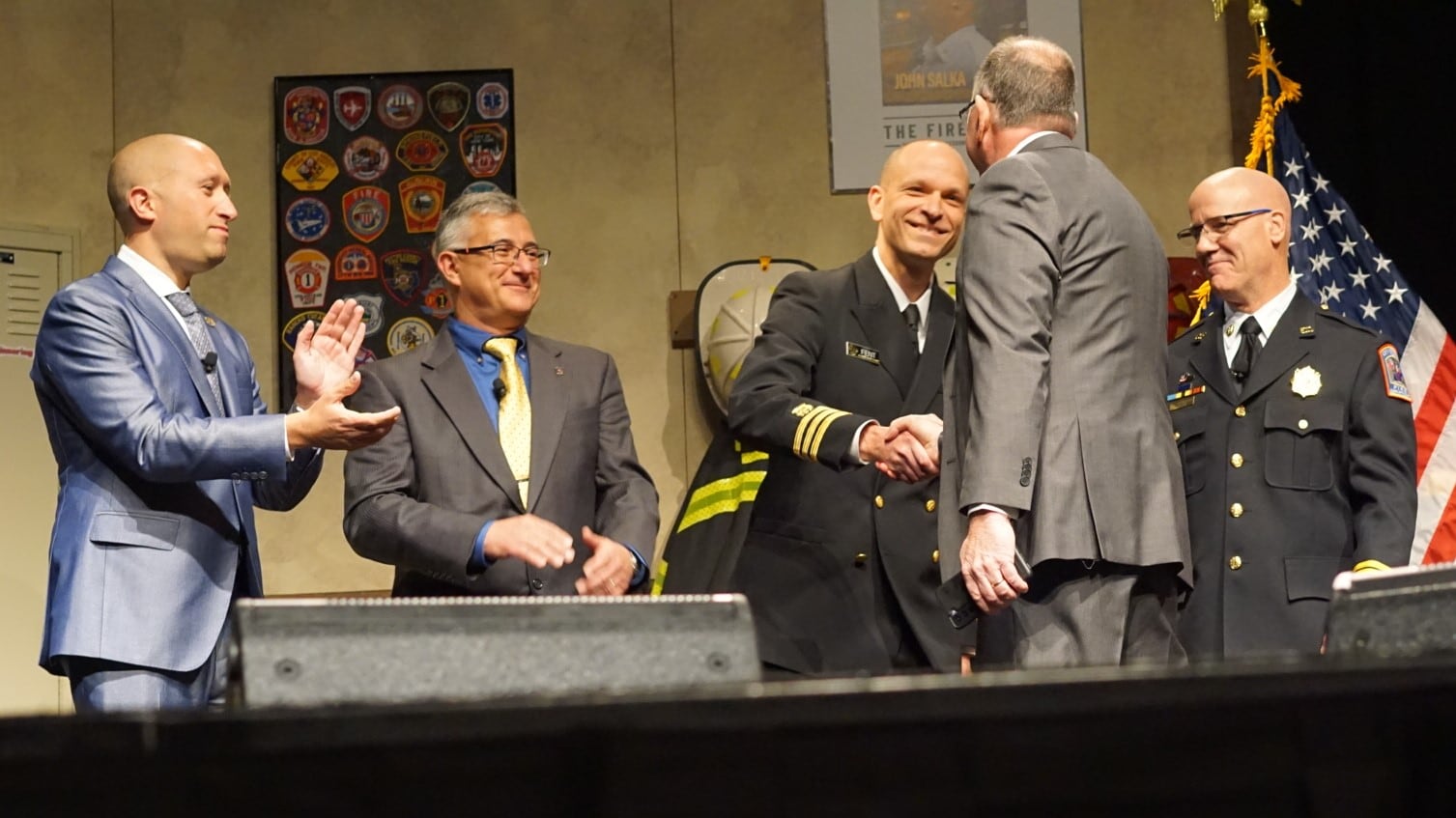 Kenny Fent (NIOSH) shakes hands with David Rhodes (Fire & Rescue) on stage at FDIC after signing up for the NFR. Andrew Pantelis (IAFF), Victor Stagnaro (NFFF), and Joe Schumacher (FCSN) also shared their support for the NFR.