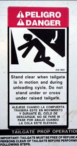 Photo 2. Warning sign: "Stand  clear when tailgate is in motion and during unloading cycle."