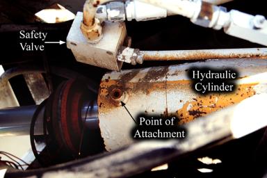 photo of lower main hydraulic cylinder showing safety valve broken off at its attachment point