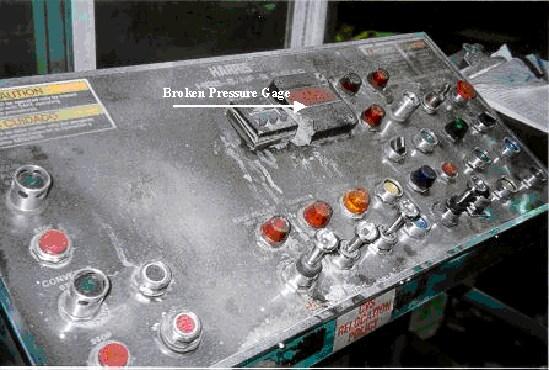 baler control panel, arrow  points to broken pressure gauge