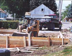 Photo 1 – View from front of skid-steer showing garage area and truck.
