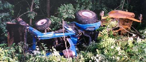 Photo 1 – Side view of the tractor in a roadside ditch after the overturn.