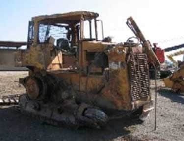 The D6H Caterpillar following the incident shows noticeable damage – missing the front blade, rear grapple, and tracks – but the operator’s cage is relatively intact.