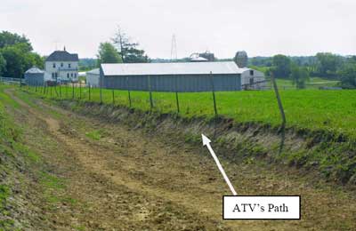 Photo 2 – View of the field drive and the approximate location of the rollover. The field is about three feet higher than the road.