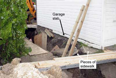 arrows point to the garage slab and pieces of sidewalk in the collapsed trench.