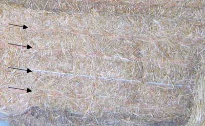Nylon strings indicated by arrows around the hay bale