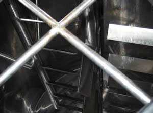 Horizontal blades viewed through newly-installed bars across hatch of fermentation tank