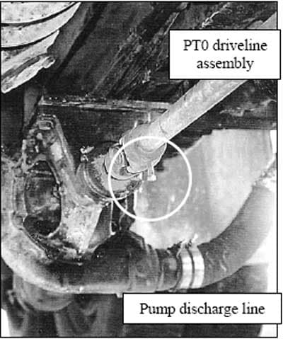 On the rear undercarriage of the water truck, the protruding set screw can be seen on the PTO driveline, near the U joint connection, which caught the collar of the victim’s coveralls and entangled him.