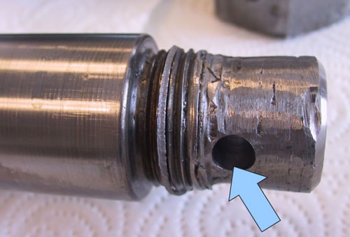 Photo 4. The thread of the failed cylinder rod was ground off and a hole had been drilled through the rod.
