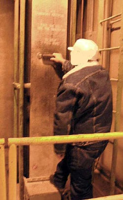 A worker at the mill demonstrates use of the manlift to ride between floors.