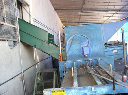 The feed chute with side panels missing and the three-foot step ladder used by the victim.