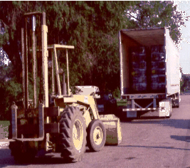 image of a bucket loader/forklift (loader) and a semi trailer