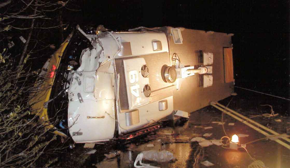Photo 1.  Photograph of Rescue 1 shortly after impact with the tree.  Photograph was taken of the truck lying on its driver's side.