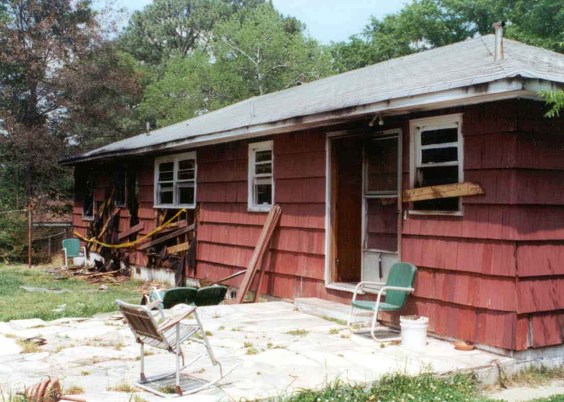 Photograph of the incident scene, showing burned out structure.