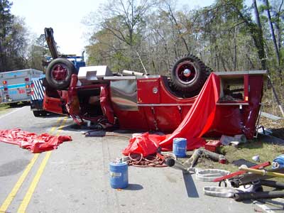 fire truck upside down after rollover in the middle of the road.