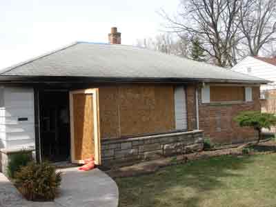 Windows and doors boarded up on the house.