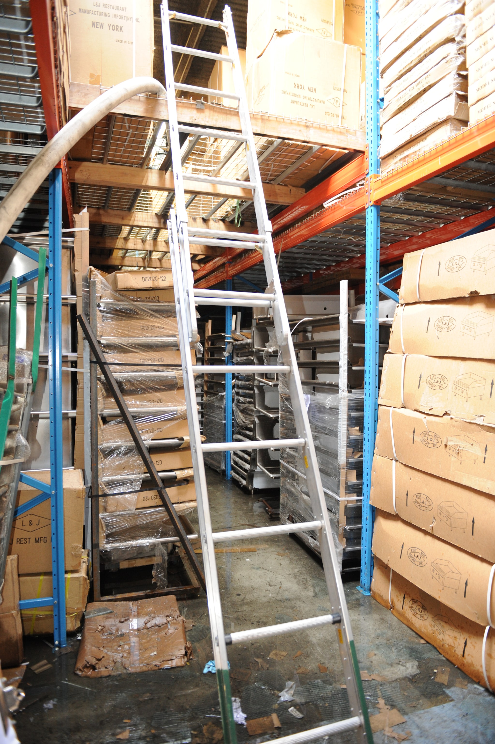 An extension ladder from the floor of the storage area raised to the “catwalk” storage area.  Both storage areas contain large cardboard boxes.