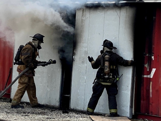 Two firemen entering a burning building