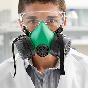 Hospital laboratory technician wearing protective eyewear and facemask.