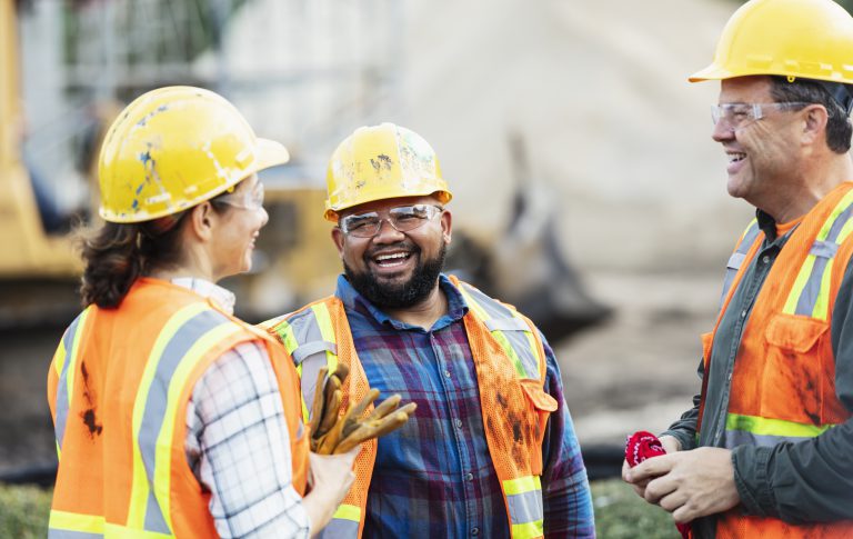 Trabajadores de construcci&oacute;n hablando y sonriendo