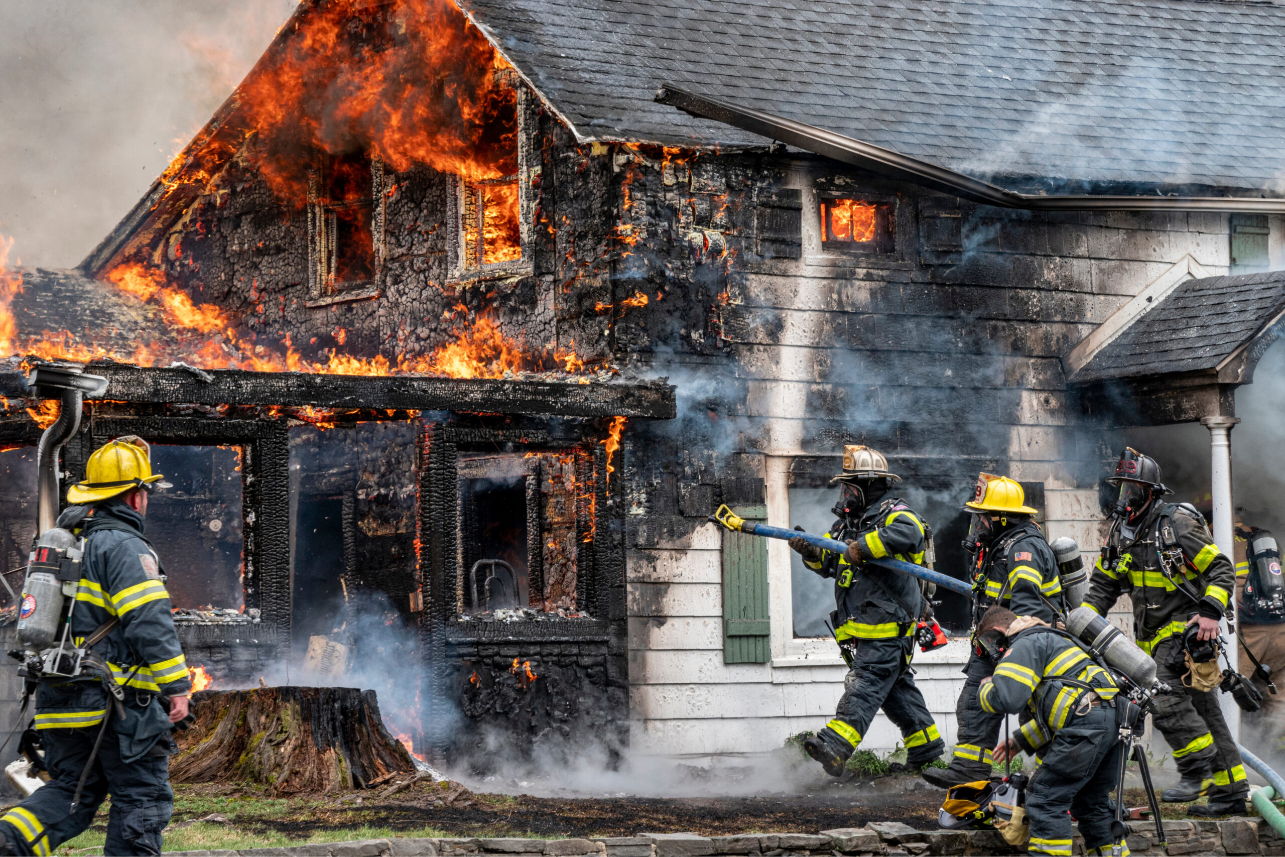 Multiple firefighters fighting a house fire.