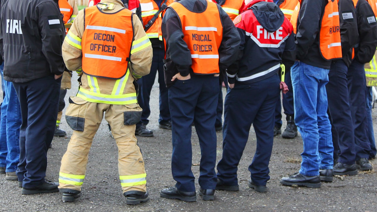 people wearing orange vests standing in circle