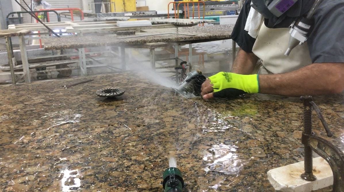 worker conducts grinding task with a wetting method of combining water spray and sheet-wetting.