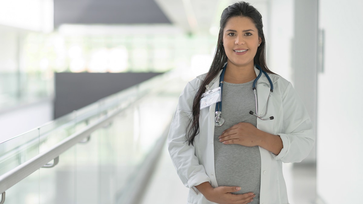 Pregnant female healthcare worker wearing a stethoscope.