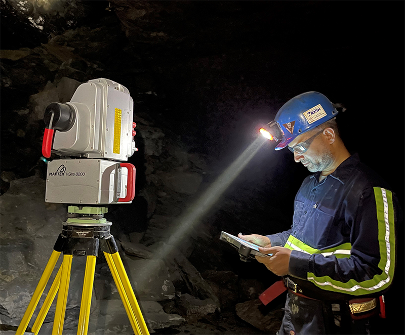 Mine worker stands next to a LiDAR scanning device