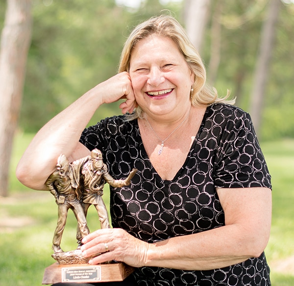 Linda Chasko, smiling, poses with her award