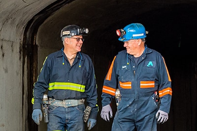 Two miners walking out of a mine