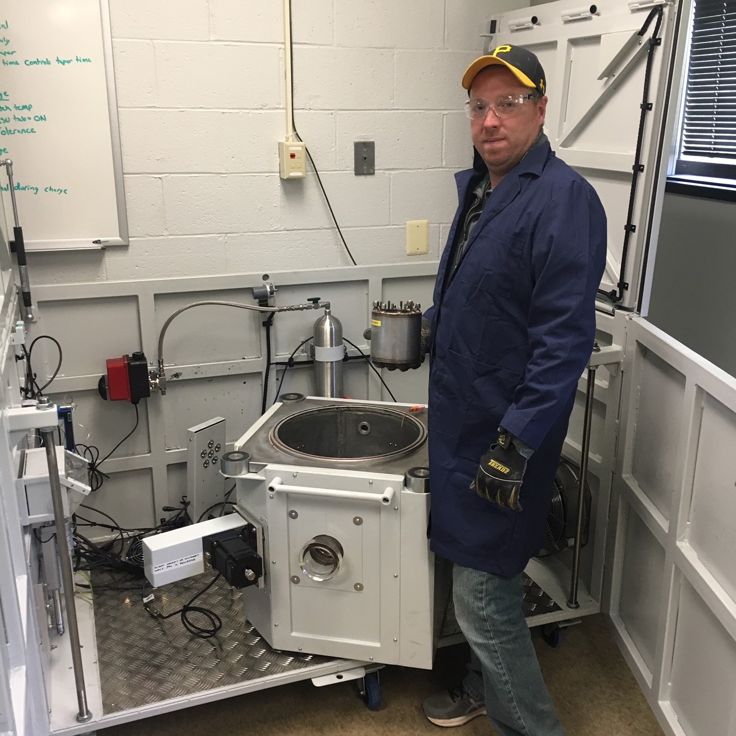 NIOSH technician standing next to accelerating rate calorimeter.