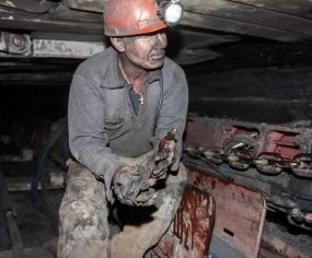 Dusty coal miner in underground mine