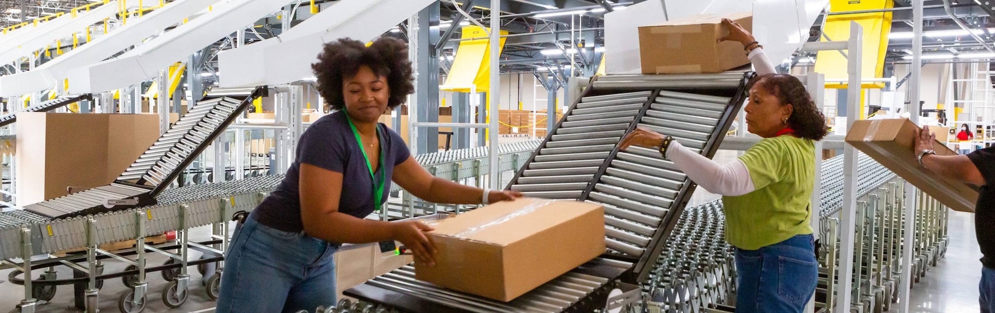 Fulfillment Center Employees Pushing Boxes Along Rollers