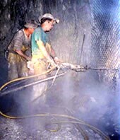 miners drilling rock, dust cloud