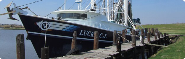 A photo of a side-trawl shrimp boat tied up at the dock