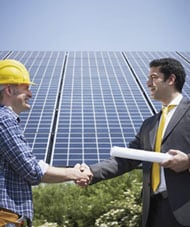 Image of workers shaking hands in front of a building certified as green