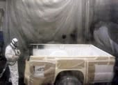 worker spraying truck bed