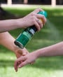 Insect repellant being sprayed on an individual's arm