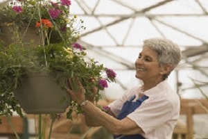 woman caring for hanging plants