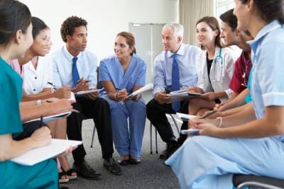 healthcare workers sitting in a circle conversing with one another