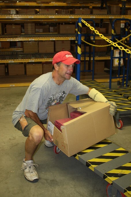 A person using the correct posture when picking up a box