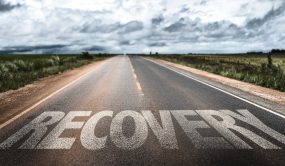 road with the word "Recovery" written on it in white paint