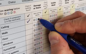 The Dampness and Mold Assessment Tool form being filled out with a pen