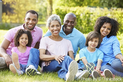 M10A Happy family of six sitting in the grass on a summer day