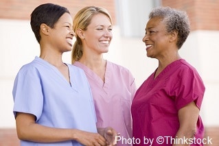 Three nurses standing are standing and smiling