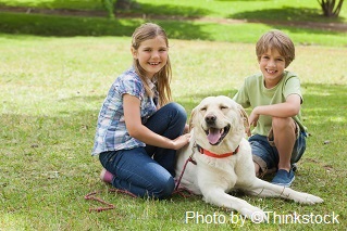 M4C Two happy children lying next to a pet dog